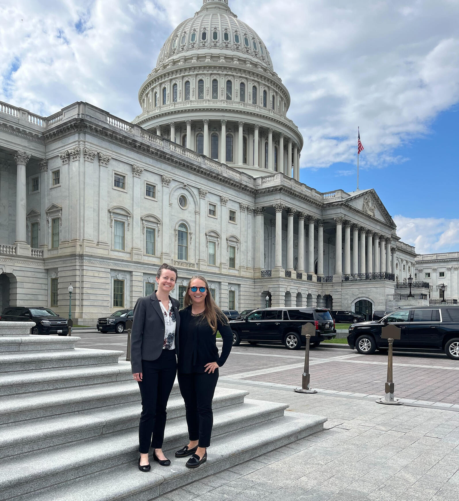 Two people stand in front of the capital building in Washington, DC.