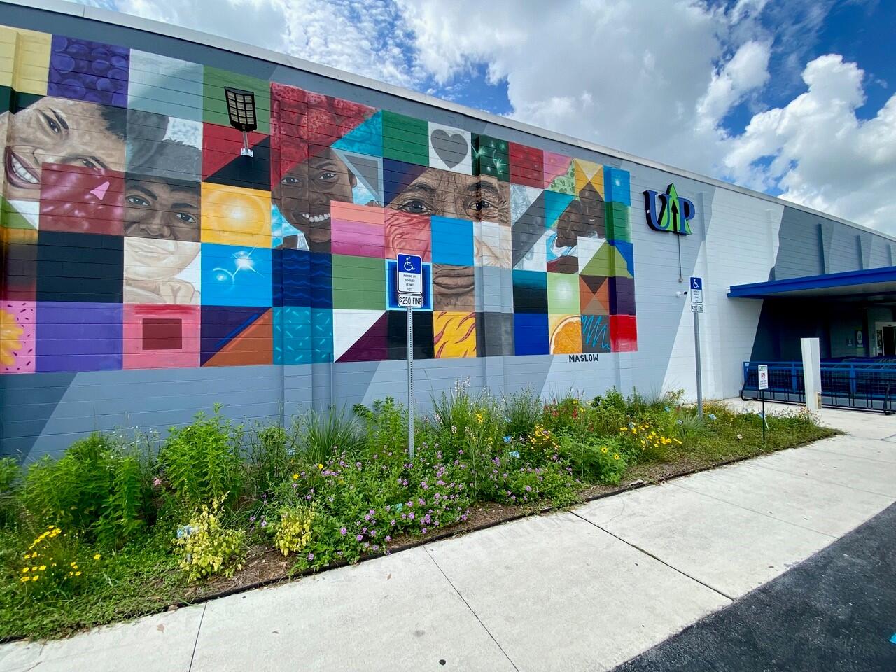 A colorful mural featuring patchwork squares of different images on the side of a building.