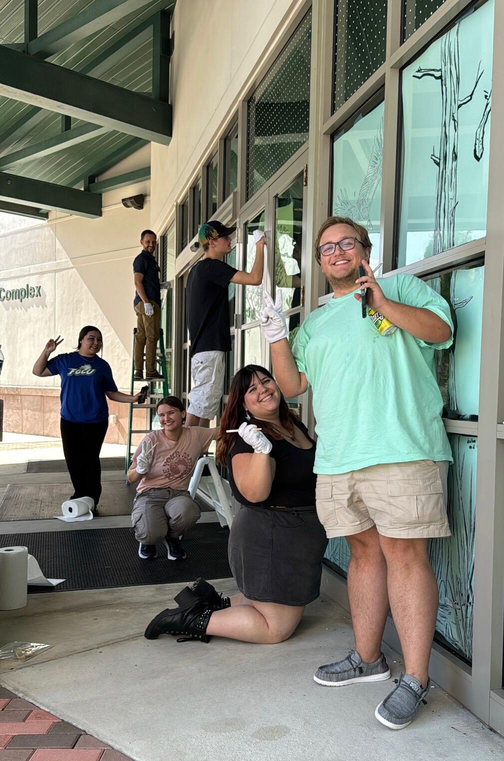 Students draw on glass windows