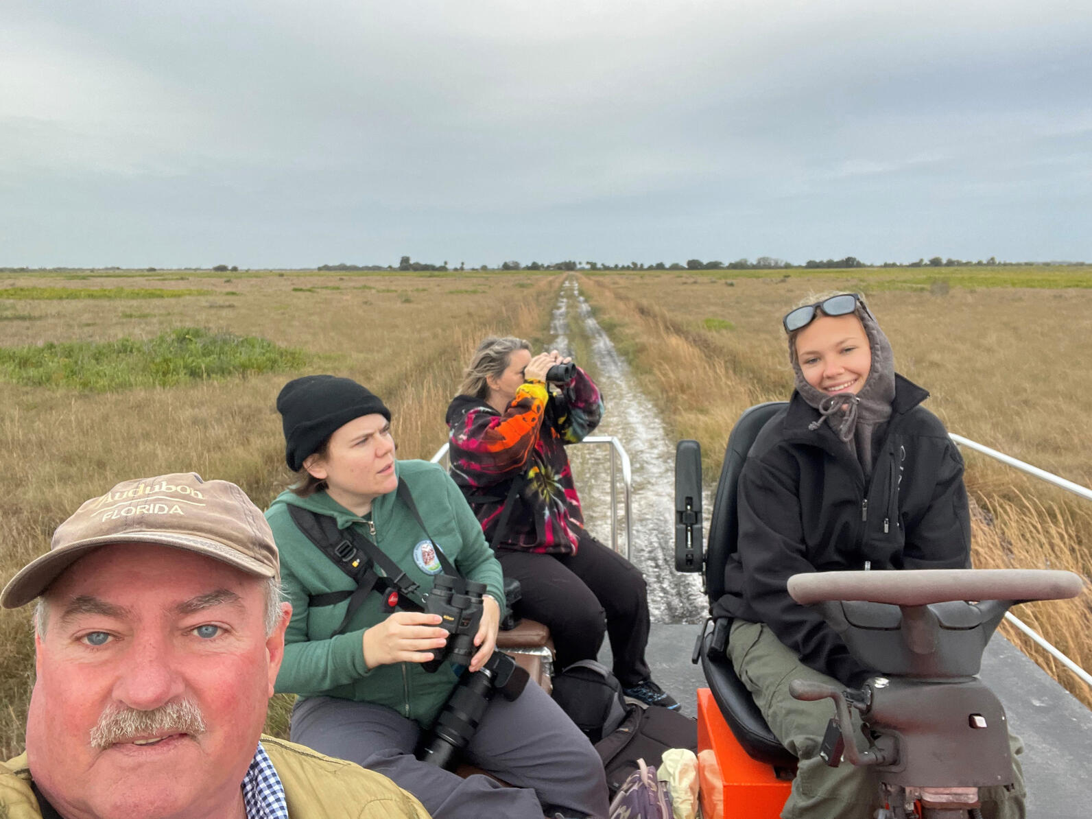 A group of four people smiling at the camera.