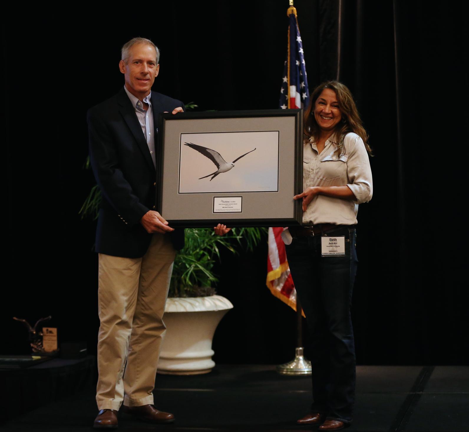 Michael Dooner receiving award from Beth Alvi.