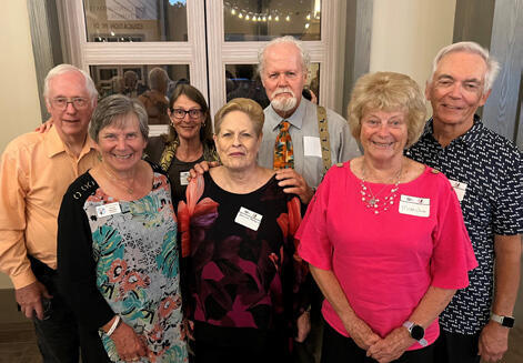 A group of people wearing nametags, smiling for a photo.