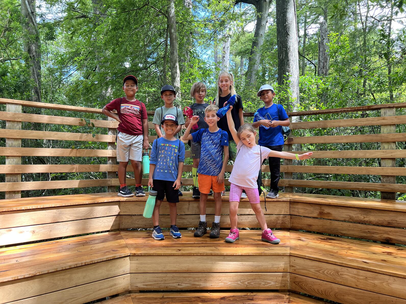 A group of students stands on the wooden amphitheater. 