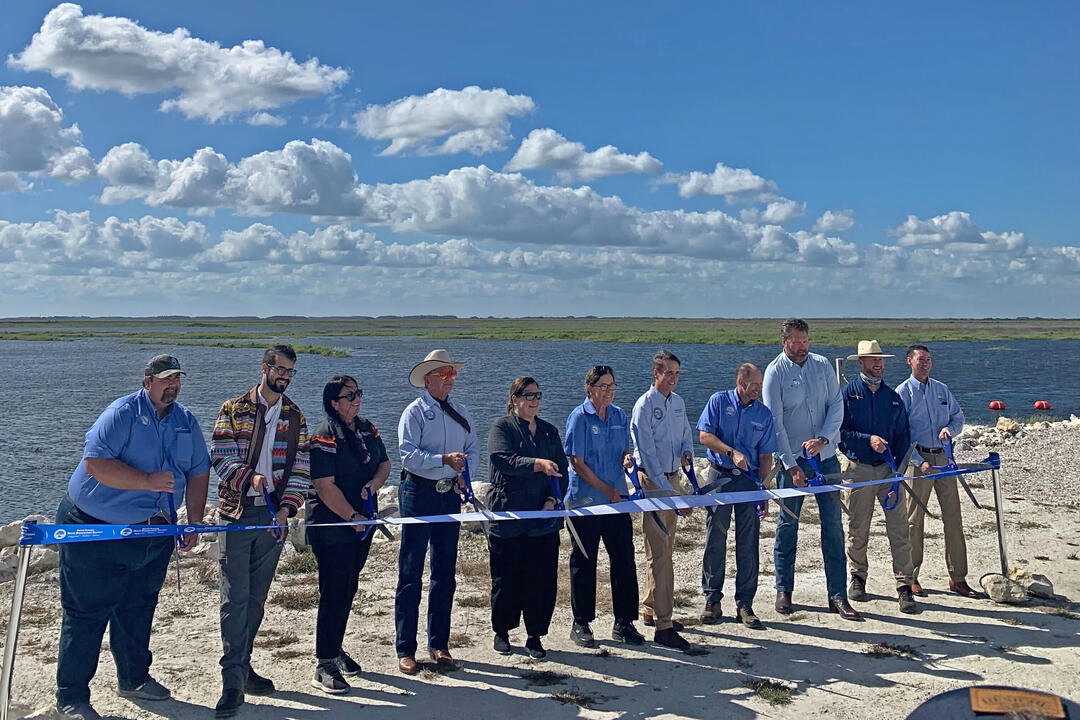 a group of people cut a giant ribbon